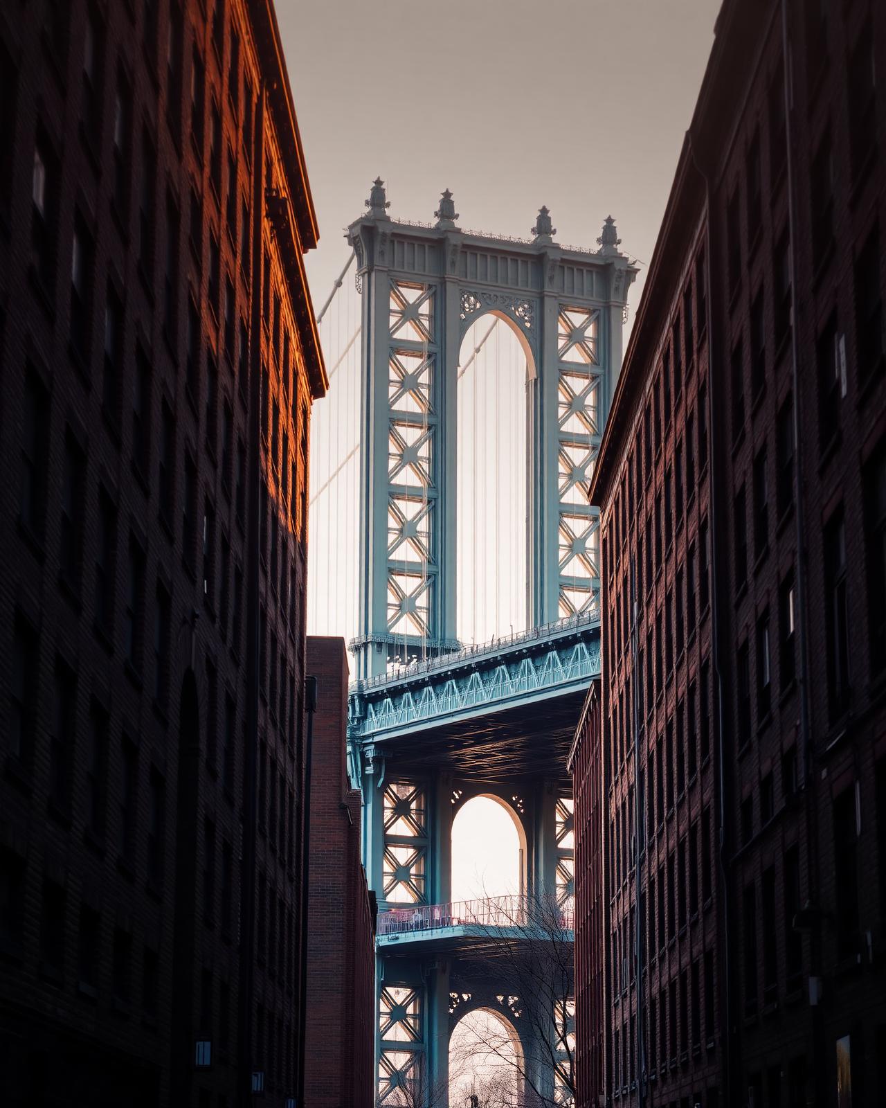 Manhattan Bridge framed between DUMBO Brooklyn buildings at golden hour
